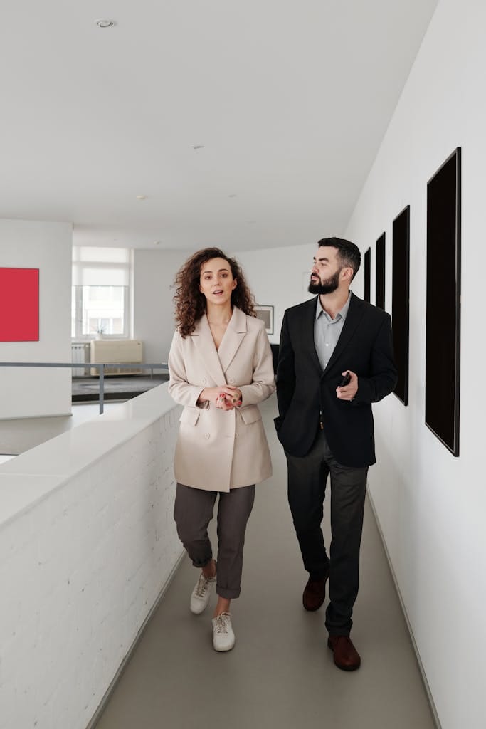 Elegant professionals walk through a sleek office interior, showcasing teamwork and partnership.